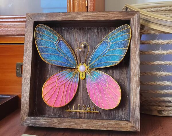 A butterfly blooming in midnight hues — deep blue, rich pink, and gold in perfect contrast.